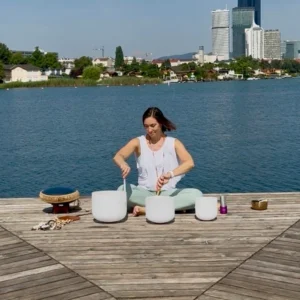 Alex spielt Crystal Bowles am Wasser, umgeben von einer inspirierenden Landschaft.